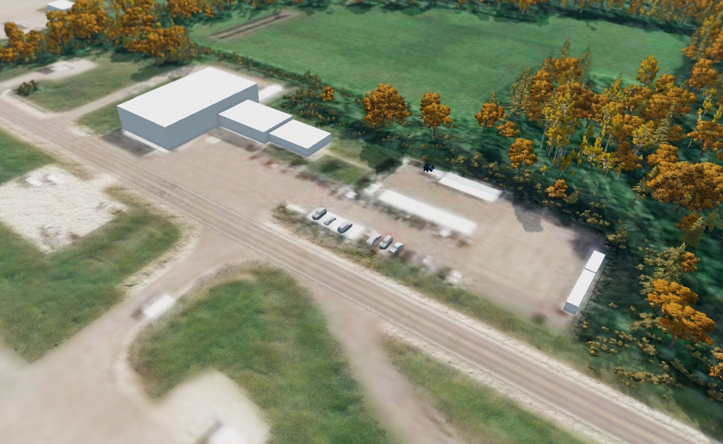 Aerial view of a spawn point beside large white placeholder buildings and parked vehicles
